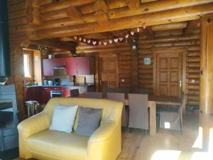 a living room with a couch and a table in a log cabin at CHALET DE L'OURS in Saint-Pierre-dels-Forcats