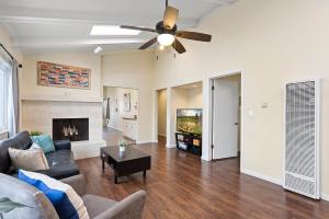 uma sala de estar com um sofá e uma ventoinha de tecto em Pacific Paradise - Large Patio, Hot Tub, Short Walk to Beach, & Parking em San Diego
