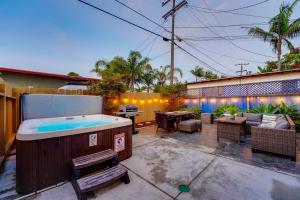 une cour avec un bain à remous et une terrasse dans l'établissement Pacific Paradise - Large Patio, Hot Tub, Short Walk to Beach, & Parking, à San Diego