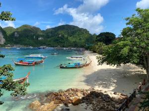 eine Gruppe von Booten an einem Strand im Wasser in der Unterkunft LONGDOO Hostel in Ko Phi Phi