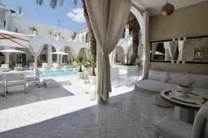 a hotel patio with a couch and a pool at Riad Palais Blanc & Spa in Marrakech