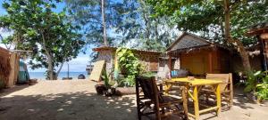 a yellow table and chairs in front of a house at Little Beach Garden in Ban Ai Dao