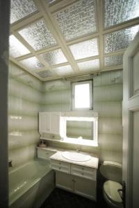 een badkamer met een wastafel, een toilet en een raam bij Κομψό & πολυτελές νεοκλασικό στο κέντρο της πόλης in Kastoria