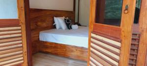 1 dormitorio con 1 cama con marco de madera en Ayubowan Holiday Home en Kandy