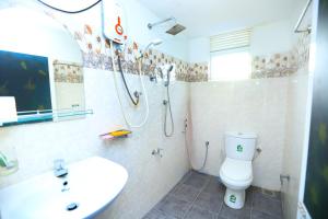 a bathroom with a shower and a toilet and a sink at villa surendra in Weligama +15 photos