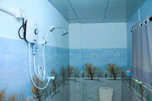 a bathroom with a shower with a painting on the wall at villa surendra in Weligama