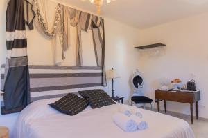 a bedroom with a white bed with towels on it at Villa Gerani in Bordighera