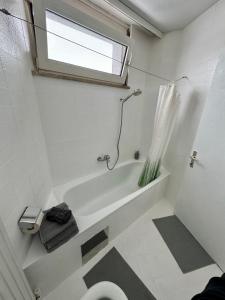 ein Bad mit einer Badewanne, einem WC und einem Fenster in der Unterkunft Studio im Herzen von Dornbirn mit Dachterrasse in Dornbirn