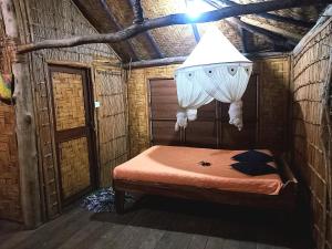 a bedroom with a bed with a light above it at Tanna friendly bungalow in Lénakel