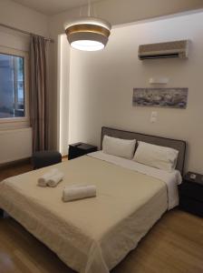 1 dormitorio con 1 cama con 2 toallas en Athenian Center Athens Kolonaki en Atenas
