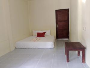 un dormitorio con una cama con un animal de peluche en MBE BALENG KU, en Mangsit