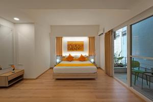 Nest By Rivido Apart Hotel, Bannerghatta road في بانغالور: غرفة نوم مع سرير مزدوج كبير وشرفة