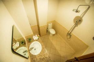 uma casa de banho com um lavatório, um WC e um espelho. em Soubundith Hotel em Pakse