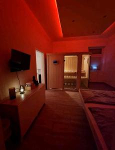 ein rotes Zimmer mit einem Bett und einem TV in der Unterkunft Apartment mit Whirlpool, Wasserbett & Sauna in Gelsenkirchen