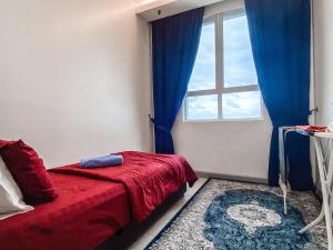 um quarto com uma cama vermelha e uma janela em D'Grand Homestay Tanjung em Kuala Terengganu