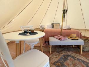 Zimmer mit einem Tisch und einem Bett in einem Zelt in der Unterkunft Foxton Beach Holiday Park in Foxton Beach