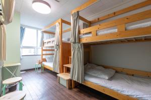 a room with two bunk beds and a table at Almas Guest House(アルマス） in Nagasaki