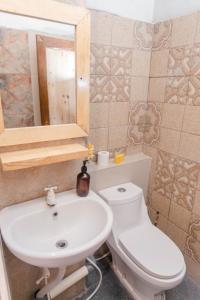 a bathroom with a white toilet and a sink at Pigeon Mandala Apartments & Resto in Nusa Dua