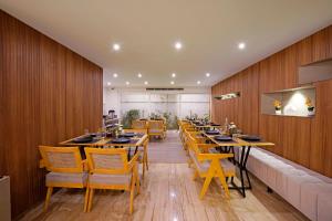 a restaurant with wooden walls and tables and chairs at Nest By Rivido Apart Hotel, Bannerghatta road in Bangalore