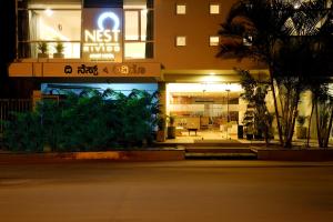 un bâtiment avec un panneau à l'avant dans l'établissement Nest By Rivido Apart Hotel, Bannerghatta road, à Bangalore