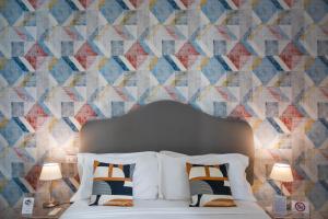 a bedroom with a bed with a geometric wallpaper at casa mo room and suite in Palermo
