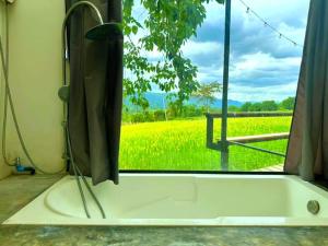 a bath tub with a view of a rapeseed field at Heaven Hill Camping in Ban Thung Na