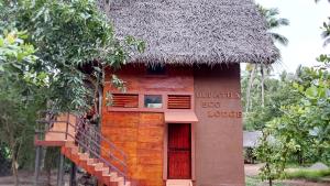 a small house with a thatched roof and a staircase at ULPATHA ECO LODGE in Kurunegala