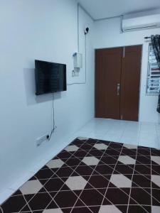 a room with a black and white checkered floor and a door at Homestay Taman Kota Emas 