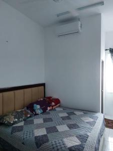 a bedroom with a bed with a quilt on it at Homestay Taman Kota Emas 