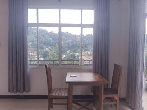 a table and two chairs in front of a window at Royal Bath Edge in Kandy