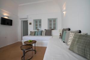 Santorini-treasures Rosemary villa traditional في Emporio: غرفة معيشة بيضاء مع أريكة وطاولة