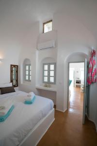 a white bedroom with a large bed and a mirror at Santorini-treasures Rosemary villa traditional in Emporio