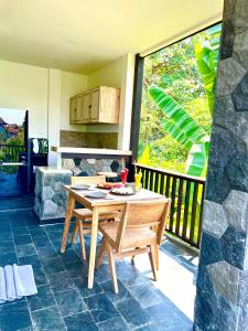 einen Holztisch und Stühle auf einer Terrasse in der Unterkunft Widya Luxury House in Ubud