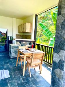 乌布Widya Luxury House的露台上的木桌和椅子