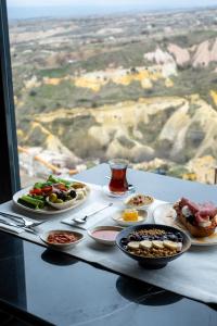 a table with plates of food on a table with a view at Vigor Cappadocia - Special Class in Uçhisar