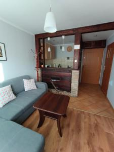 ein Wohnzimmer mit einem blauen Sofa und einem Tisch in der Unterkunft Mieszkanie w centrum in Kłodzko
