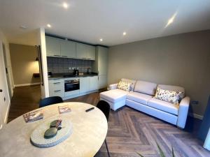 a living room with a couch and a table at The Retreat, luxury apartment in Bath with parking in Bath