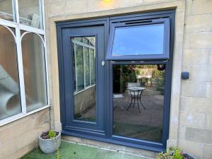 a blue door with a screen on the side of a house at The Retreat, luxury apartment in Bath with parking in Bath