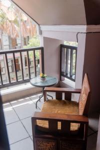 a balcony with a table and a chair and a window at Pigeon Mandala Apartments & Resto in Nusa Dua