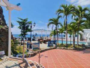a resort with a pool and palm trees and the ocean at Villa Apolonia Resort in San Juan