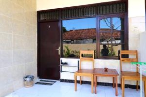 a table and two chairs in front of a door at Pondok Dete Guesthouse in Sanur