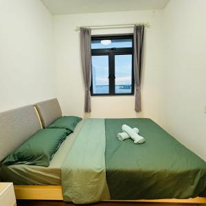 ein Schlafzimmer mit einem Bett mit zwei weißen Handtüchern darauf in der Unterkunft Ataraxia 2B1R 4pax Condo Forest City 3A-3202 in Gelang Patah + 51 Fotos