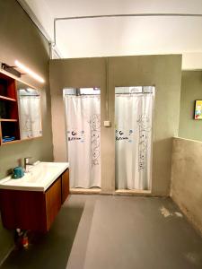 a bathroom with a sink and a shower curtain at GAR'S Homestay in Wanning