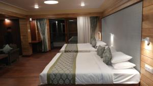 a hotel room with two beds in a room at Udaan Dekeling Resort, Darjeeling in Darjeeling