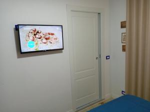 a flat screen tv hanging on a wall next to a door at B&B villamariascauri in Scauri