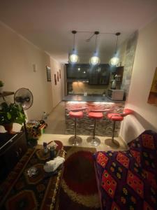 a living room with red bar stools and a kitchen at Chalet in Belagio Ain Sokhna in Ain Sokhna