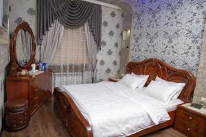 a bedroom with a large bed and a mirror at Samarkand luxury apartament #1 in Samarkand