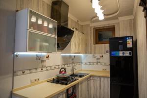 a kitchen with a black refrigerator and a stove at Samarkand luxury apartament #1 in Samarkand