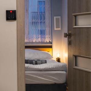 a room with a bed with a window and a door at CityOasis Apartment in Nowe Miasto Lubawskie