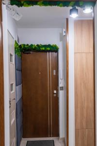 a brown door with a greenreath on top of it at CityOasis Apartment in Nowe Miasto Lubawskie